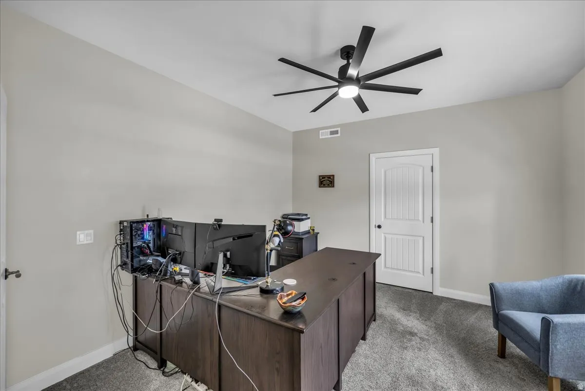 Office area featuring carpet flooring and a ceiling fan