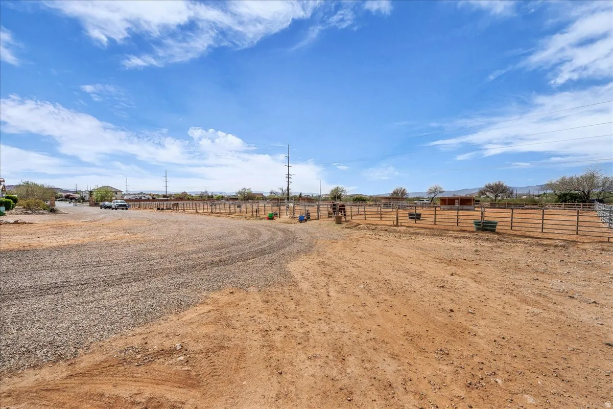 View of street with a view of countryside, an enclosed riding area, and a gated entry