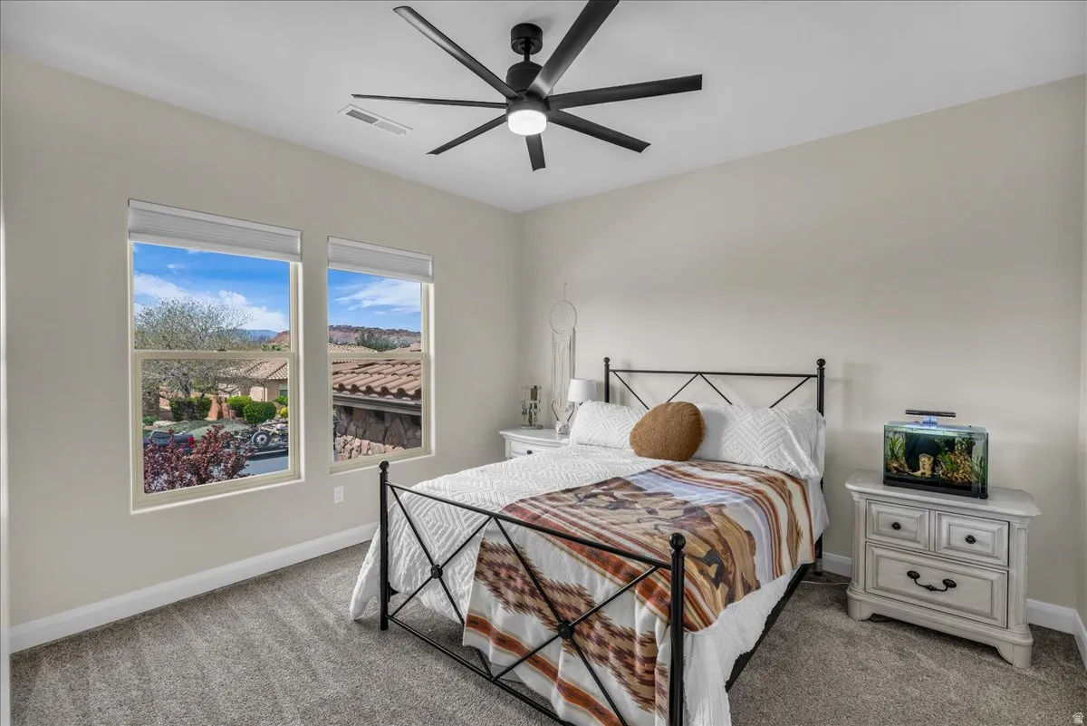Bedroom with light colored carpet and ceiling fan