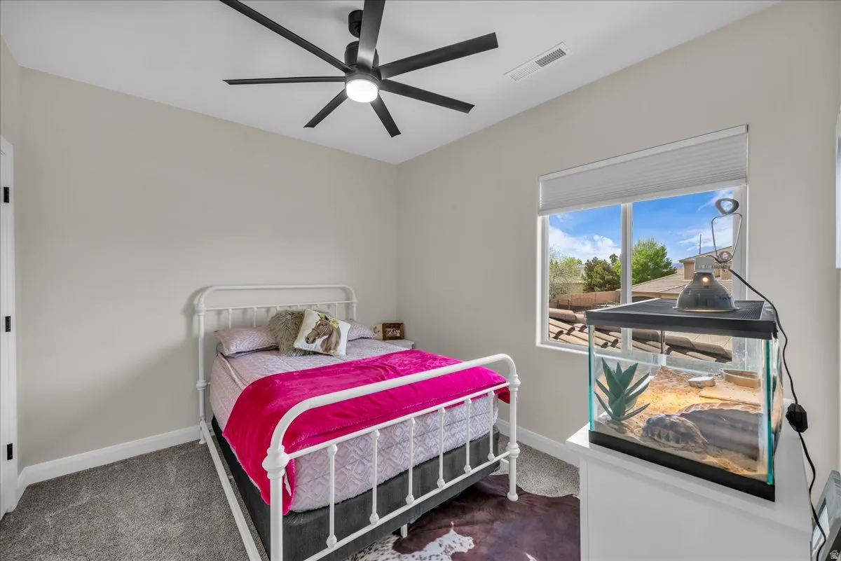 Bedroom featuring dark carpet and ceiling fan