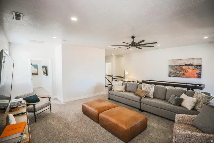 Carpeted living area featuring ceiling fan, a textured ceiling, and recessed lighting