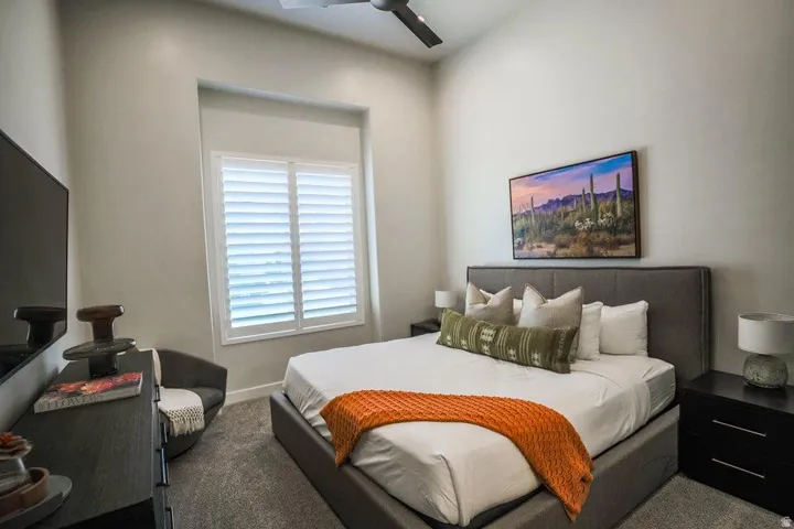 Carpeted bedroom with a ceiling fan