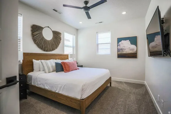 Bedroom featuring dark colored carpet and a ceiling fan