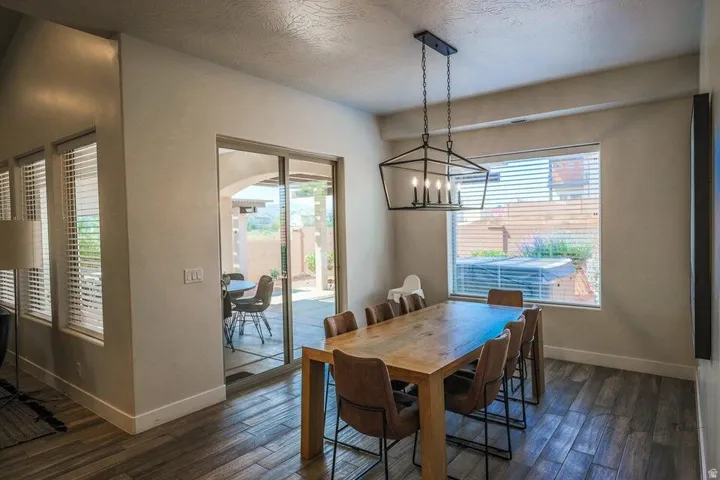 Dining space with hanging lights, dark wood finished floors, arched walkways, and a textured ceiling