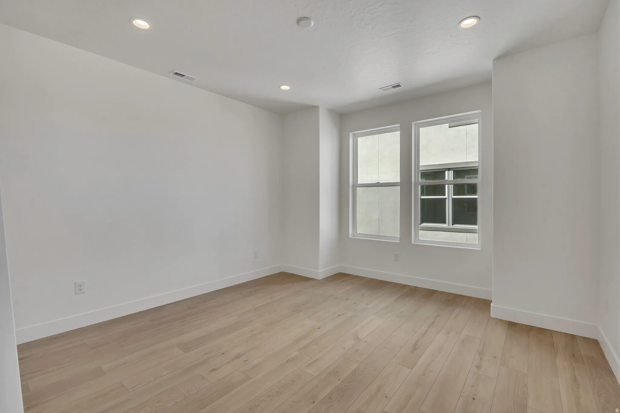 Empty room with recessed lighting and light wood-style floors