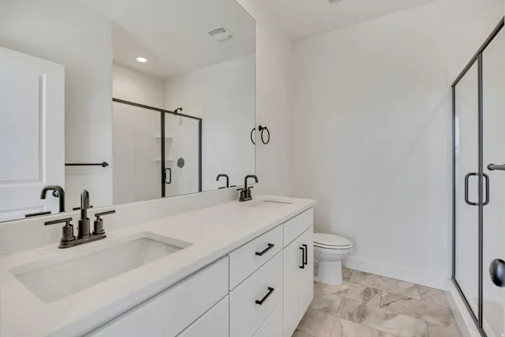 Bathroom with a shower stall and double vanity