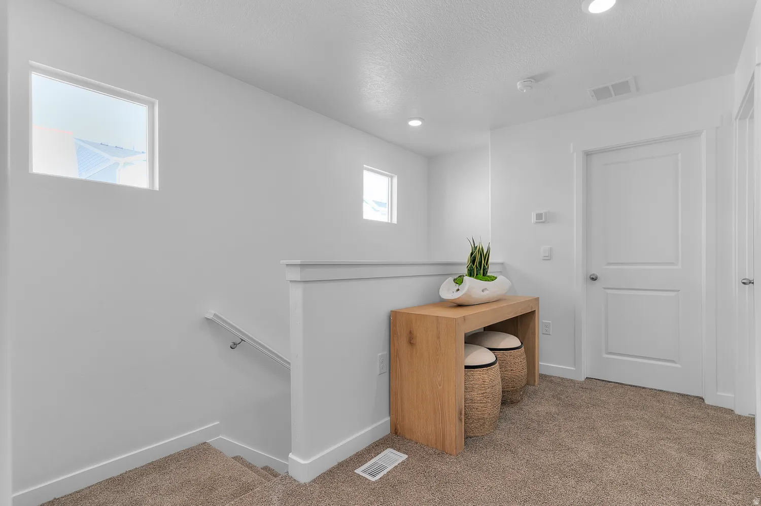 Corridor with an upstairs landing, light carpet, recessed lighting, and a textured ceiling