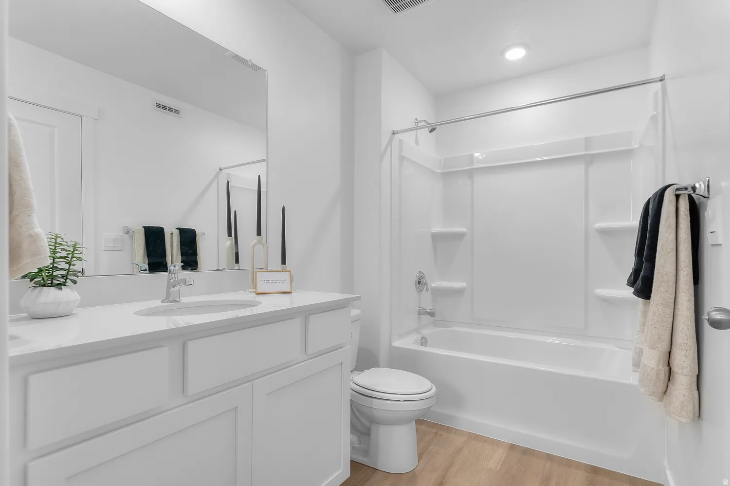 Bathroom featuring vanity, light wood-type flooring, and bathtub / shower combination