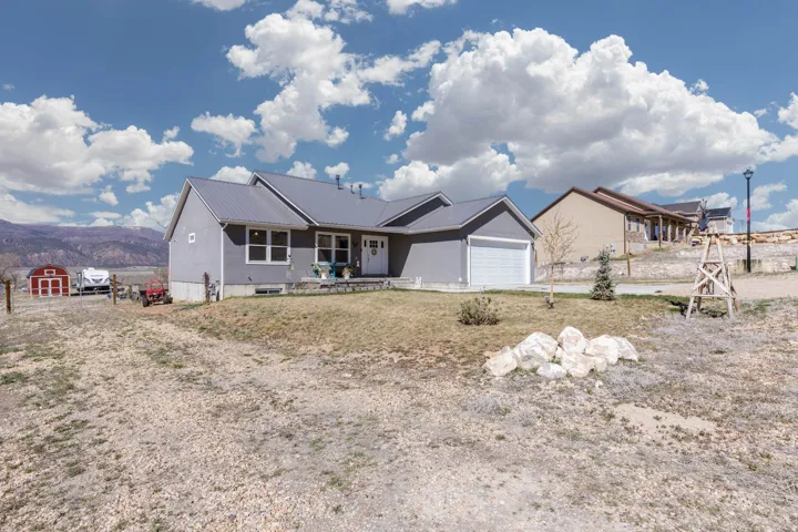 Ranch-style home featuring a mountain view, an attached garage, and a metal roof