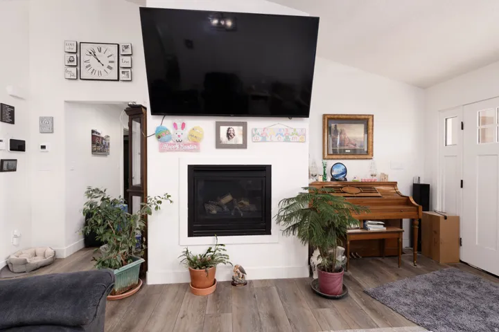 Living area with wood finished floors and a glass covered fireplace