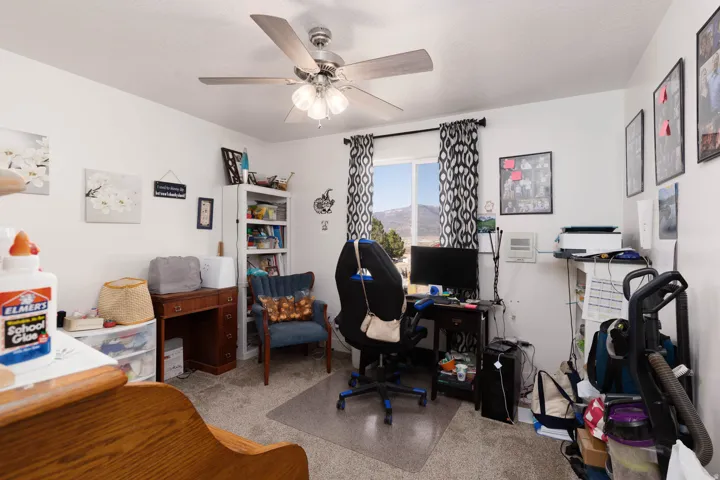 Office area featuring light colored carpet and a ceiling fan