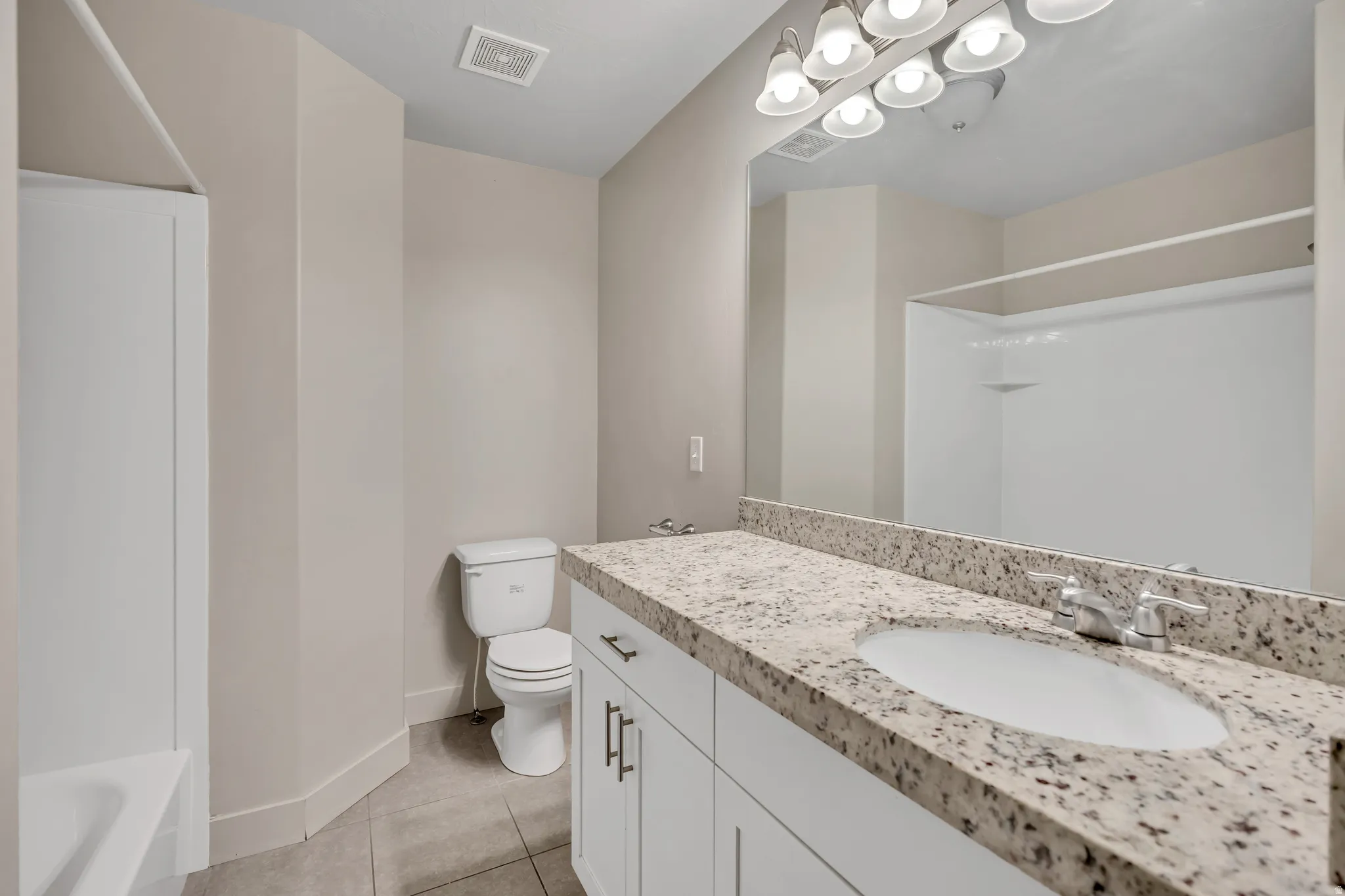 Bathroom featuring vanity, light tile patterned floors, and shower / bath combination
