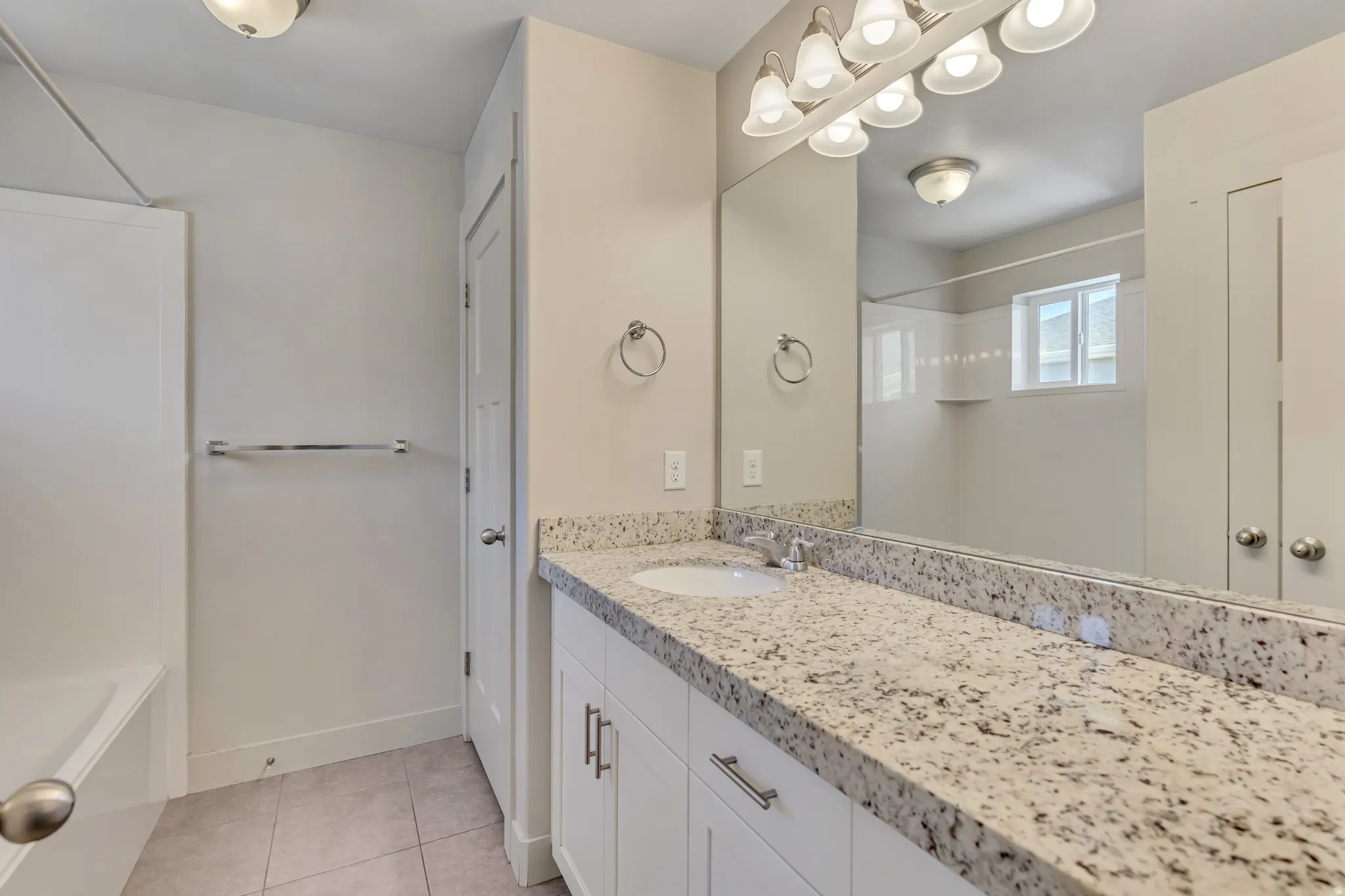 Full bathroom with vanity, tub / shower combination, light tile patterned flooring, and a closet