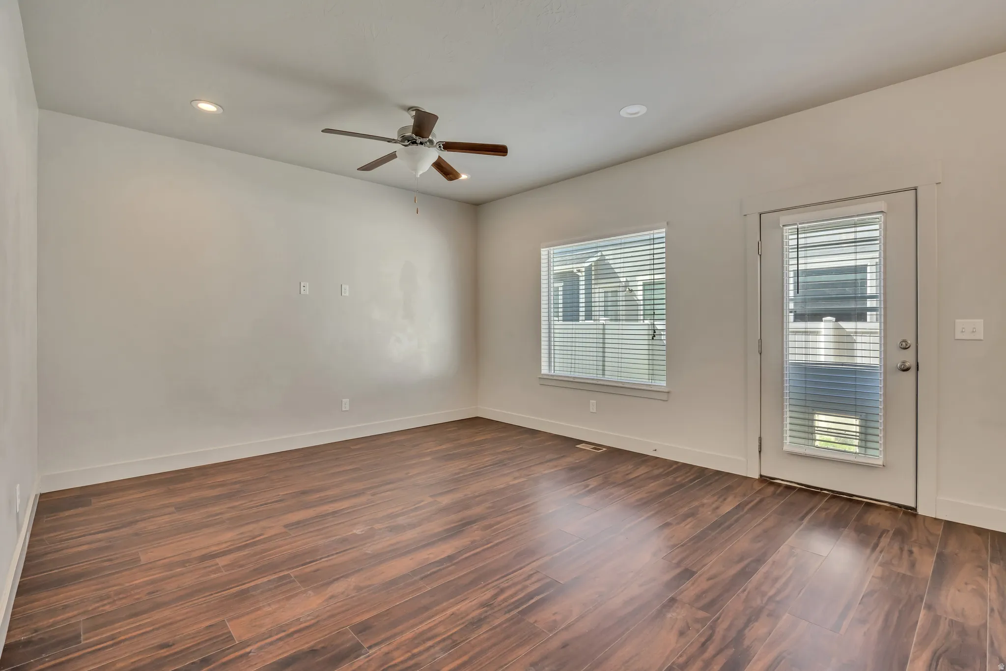 Spare room featuring dark wood-style flooring, ceiling fan, and recessed lighting