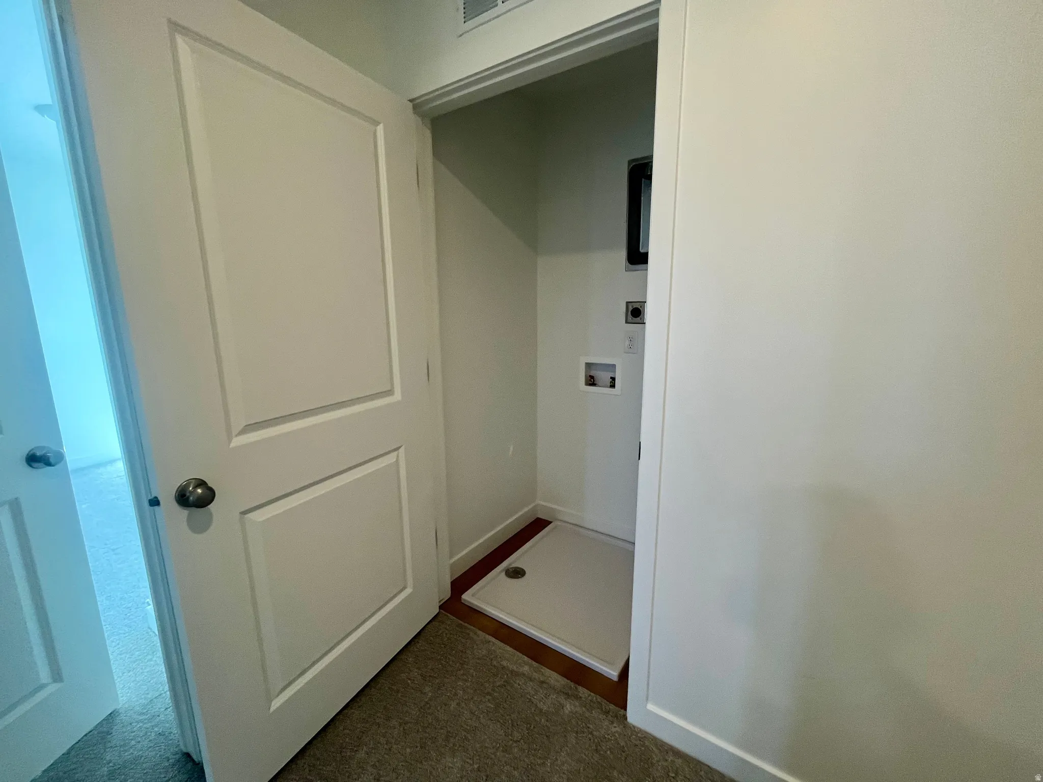 Laundry area featuring washer hookup and dark colored carpet