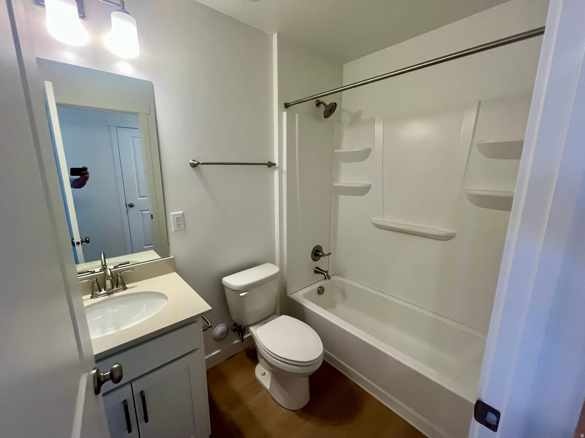 Full bathroom featuring vanity, tub / shower combination, and dark wood-style flooring