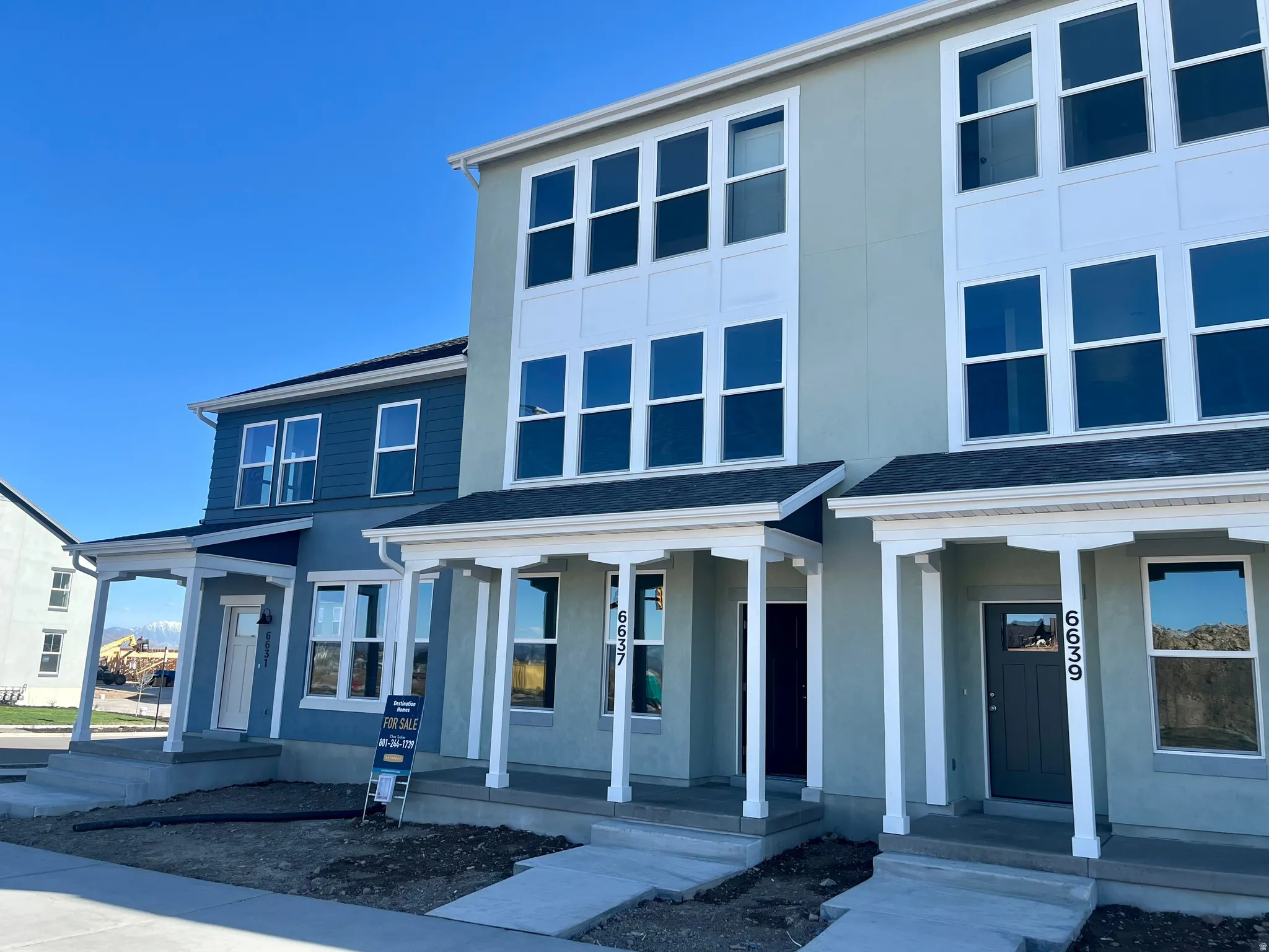 View of front of home with covered porch, stucco siding, and roof with shingles
