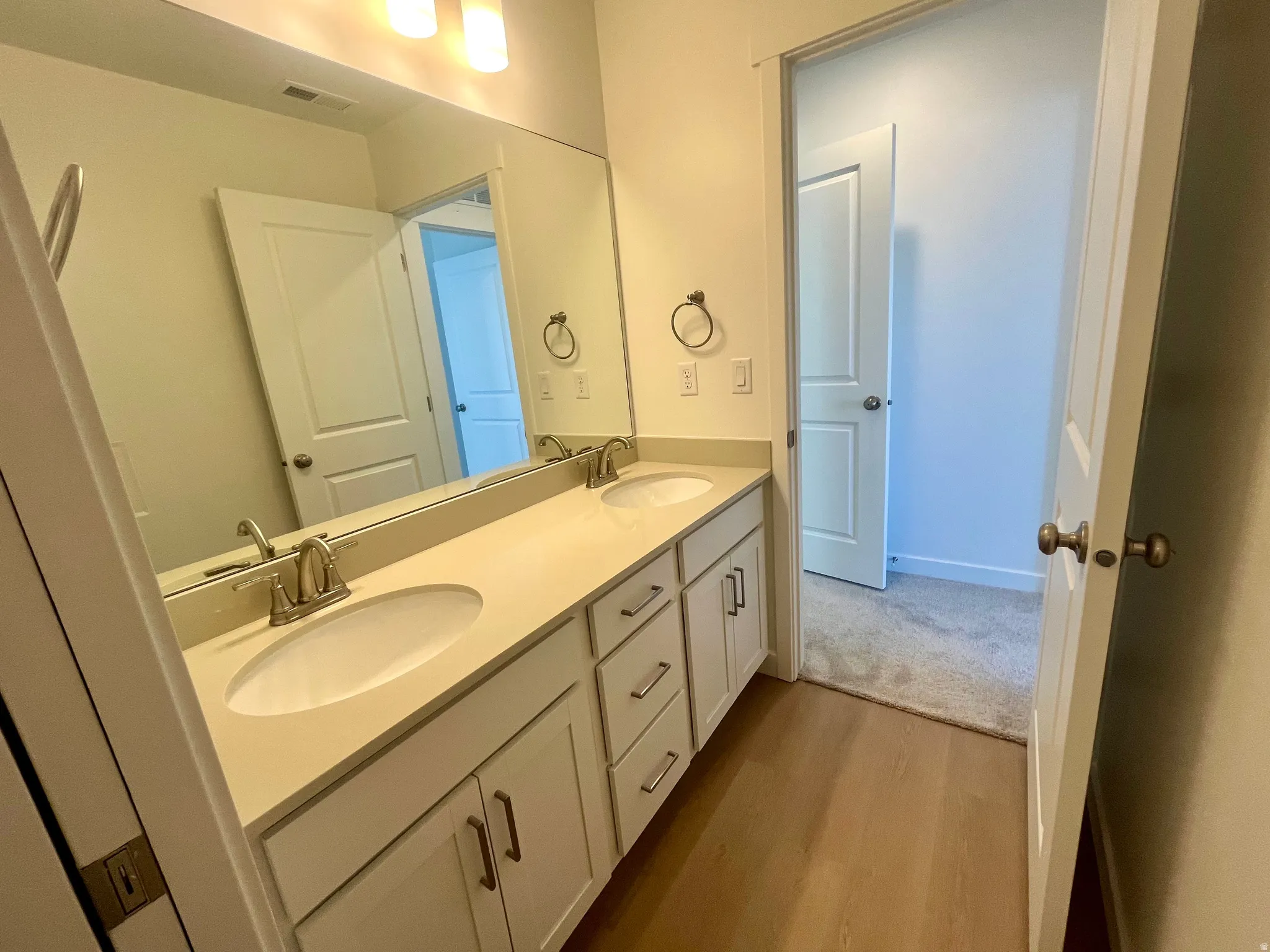 Bathroom featuring double vanity and light wood-style floors