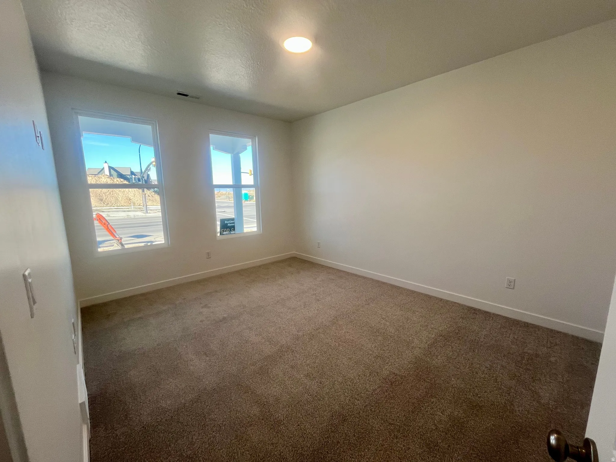 Carpeted empty room with baseboards and a textured ceiling