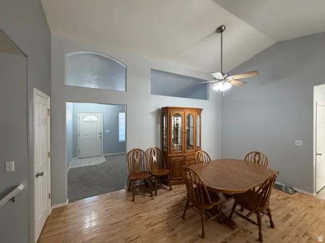 Dining area featuring lofted ceiling, light wood-type flooring, and ceiling fan