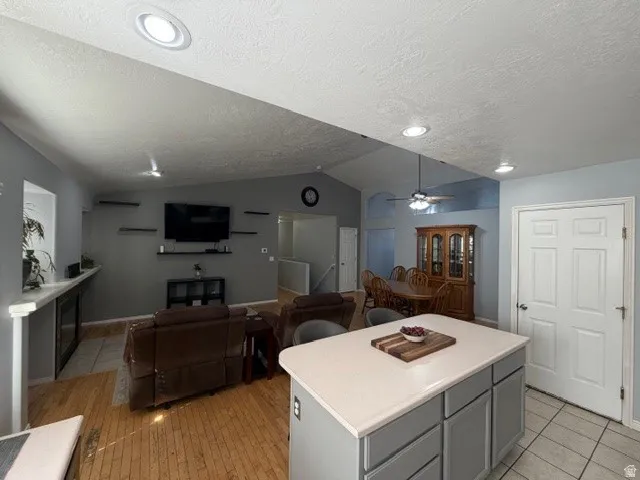Kitchen featuring open floor plan, a center island, light countertops, and gray cabinetry