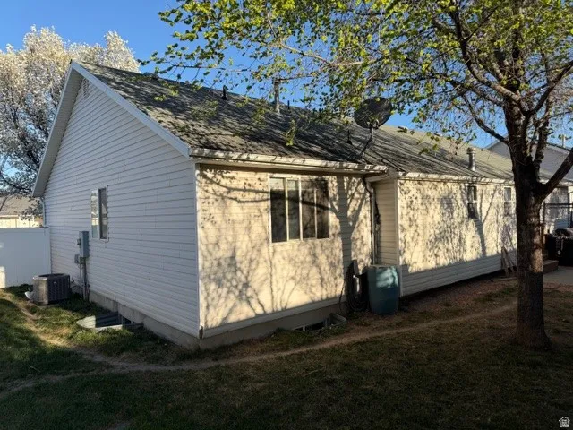View of property exterior featuring a lawn and roof with shingles