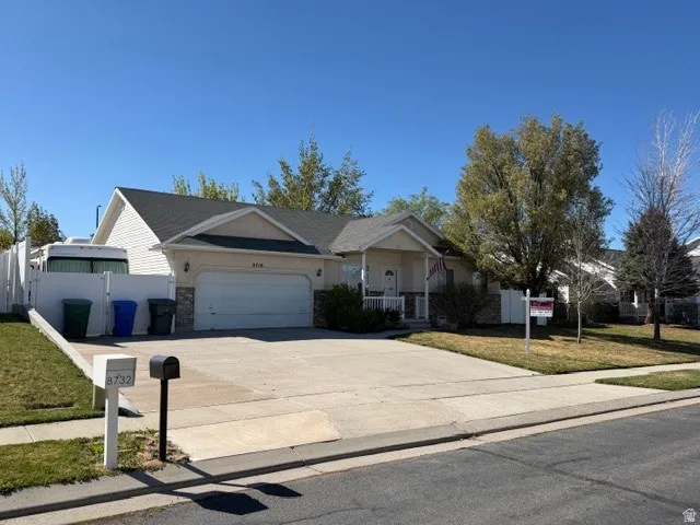 Ranch-style home with an attached garage, concrete driveway.