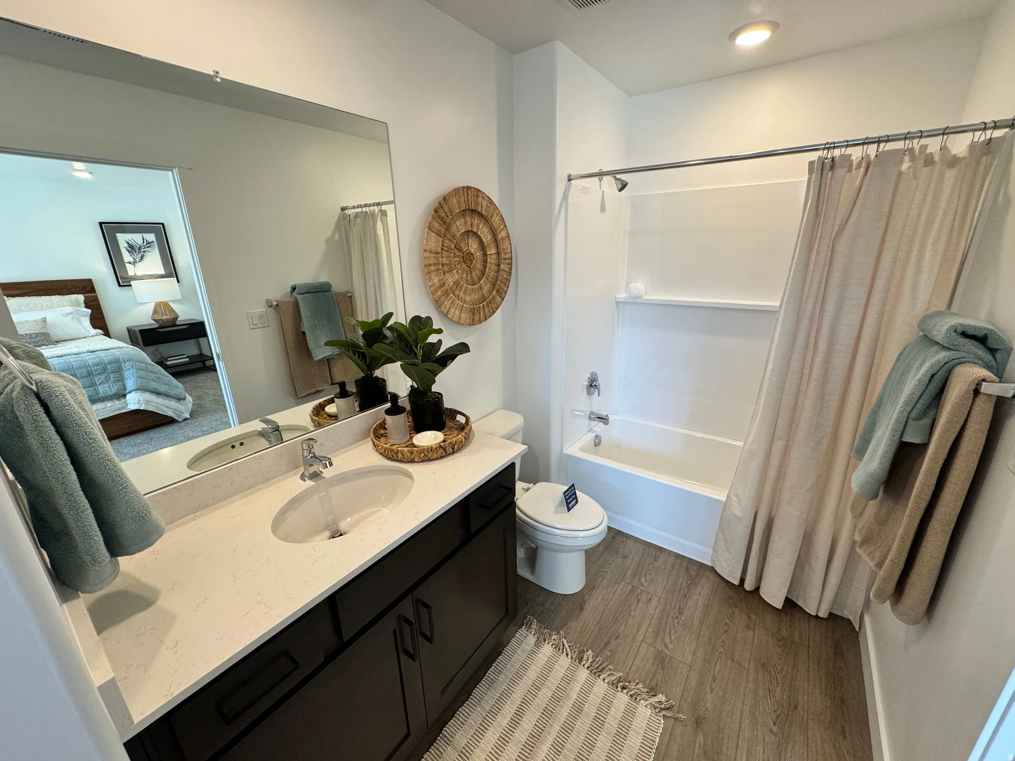 Bathroom featuring a white vanity with an integrated sink, polished chrome faucet, and expansive mirror