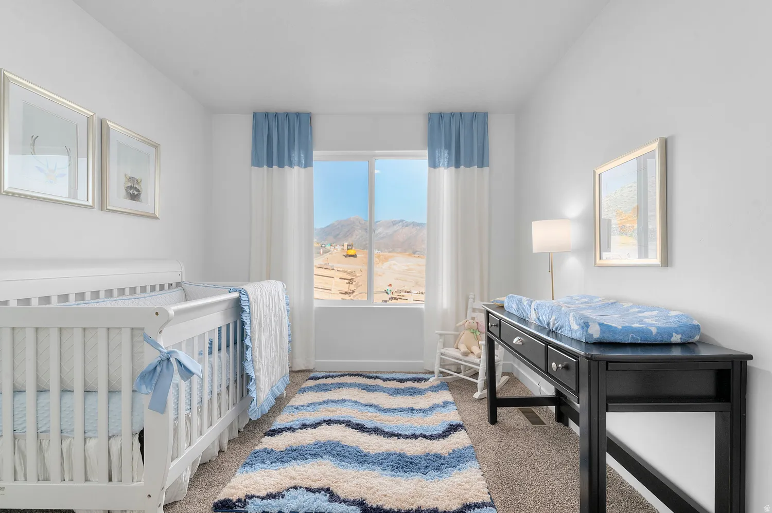 Bedroom with a nursery area, light carpet, and a mountain view