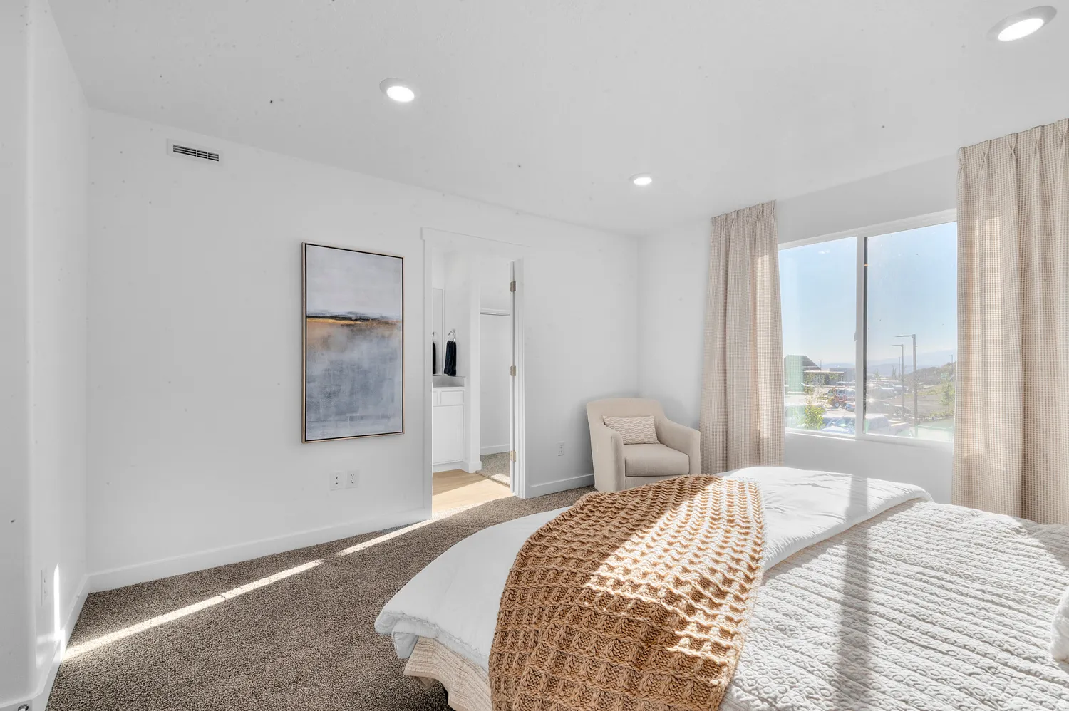 Bedroom with ensuite bath, light carpet, and recessed lighting