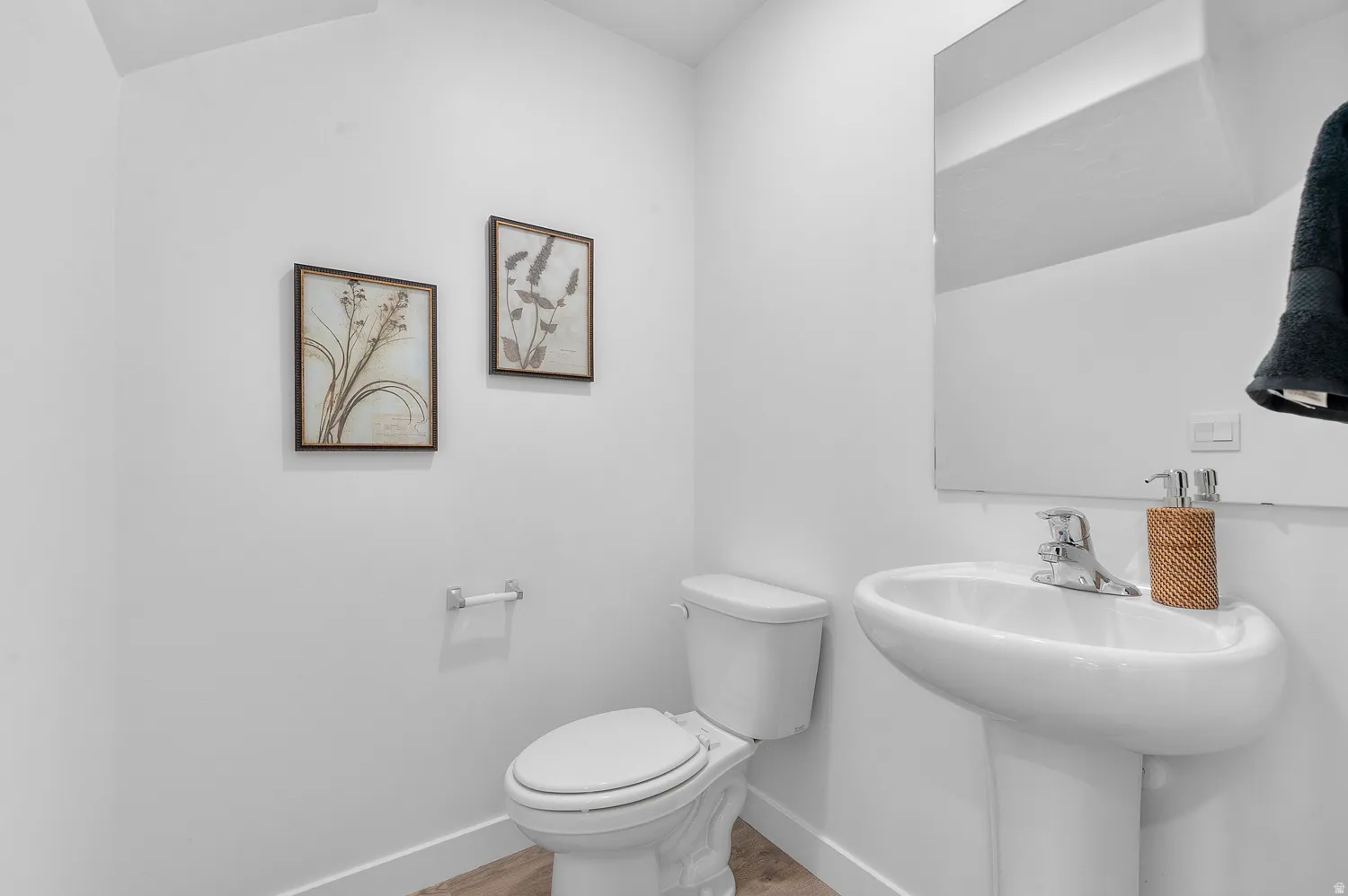 Half bath with baseboards and wood finished floors