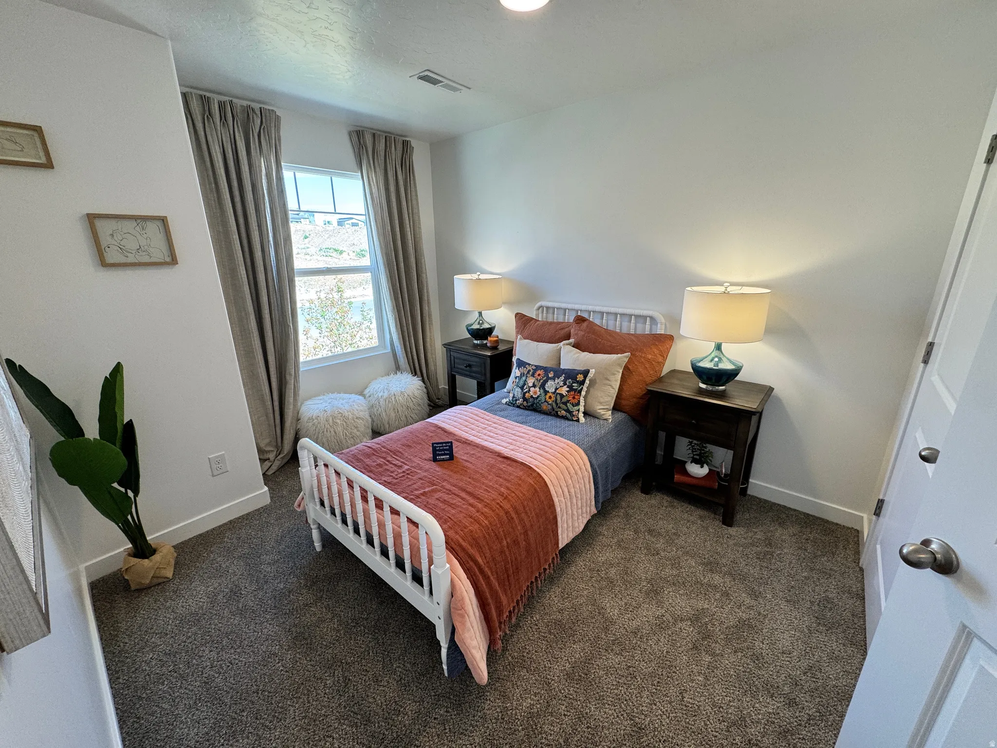 Carpeted room featuring a single window, white baseboards, and a paneled door with a brushed nickel knob