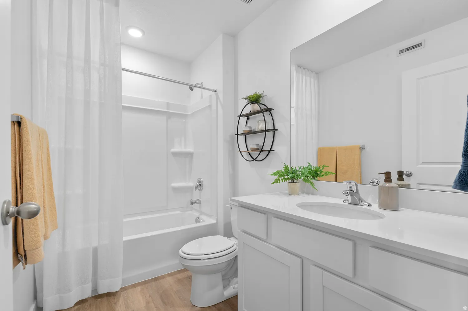 Bathroom with light wood-type flooring, vanity, and shower / tub combo with curtain