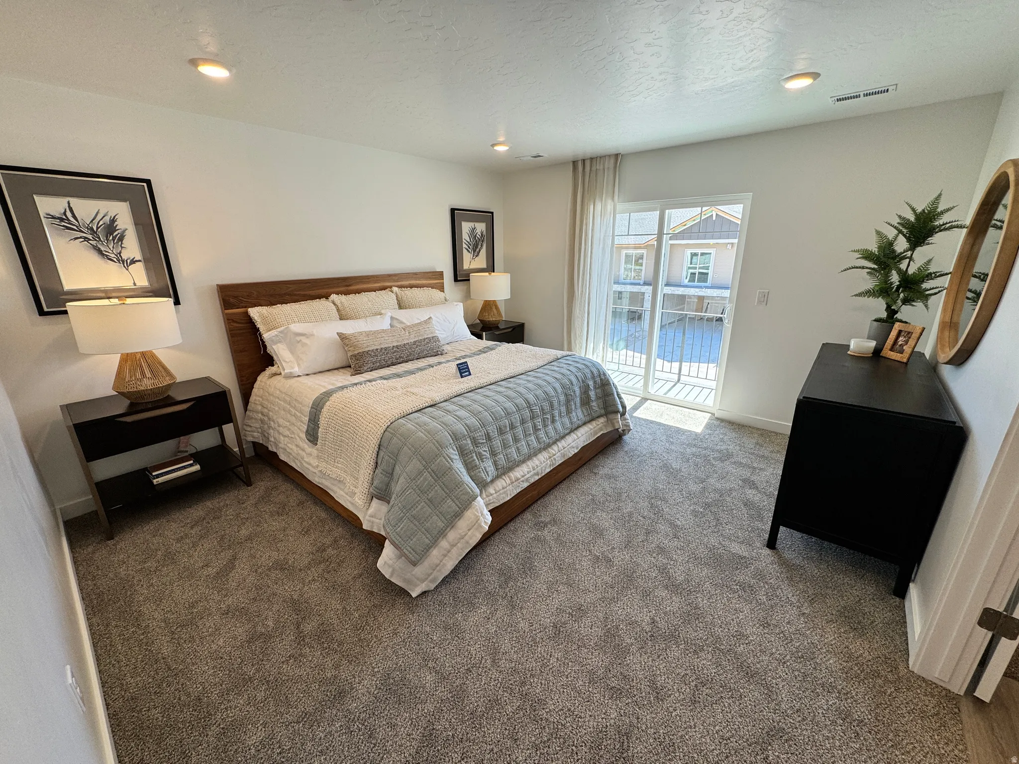 Carpeted room featuring a sliding glass door with balcony access, recessed ceiling lighting, and light-toned wall finishes