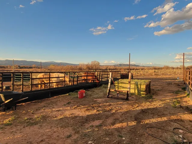 View of yard featuring a view of countryside, a mountain view, an outdoor structure, and an exterior structure