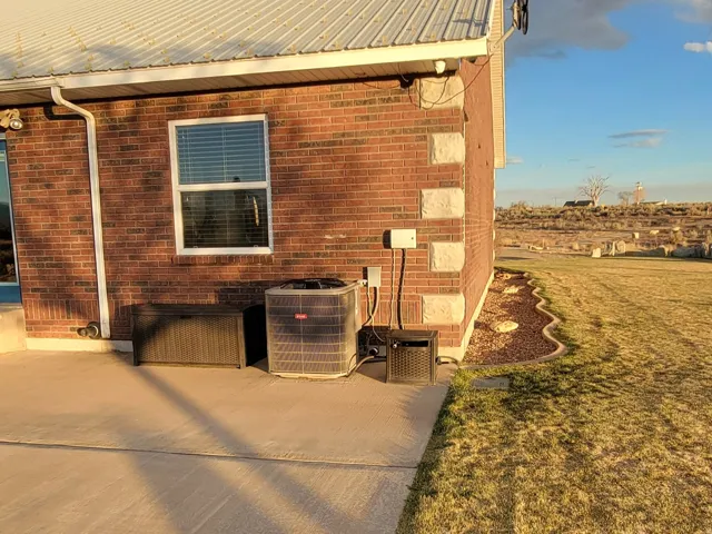 View of side of home featuring brick siding and a metal roof