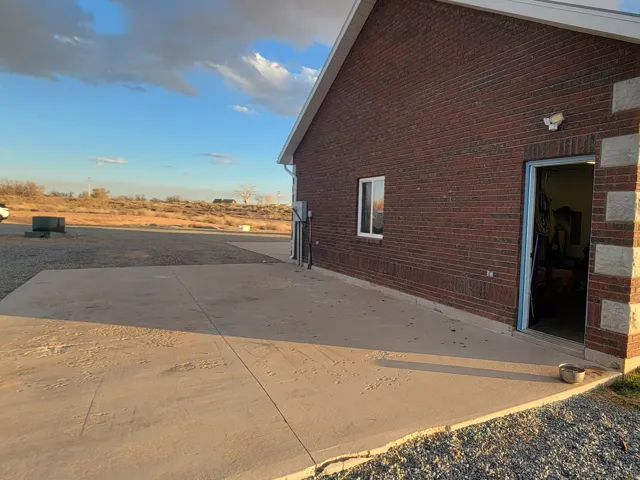 View of property exterior with brick siding and a patio area