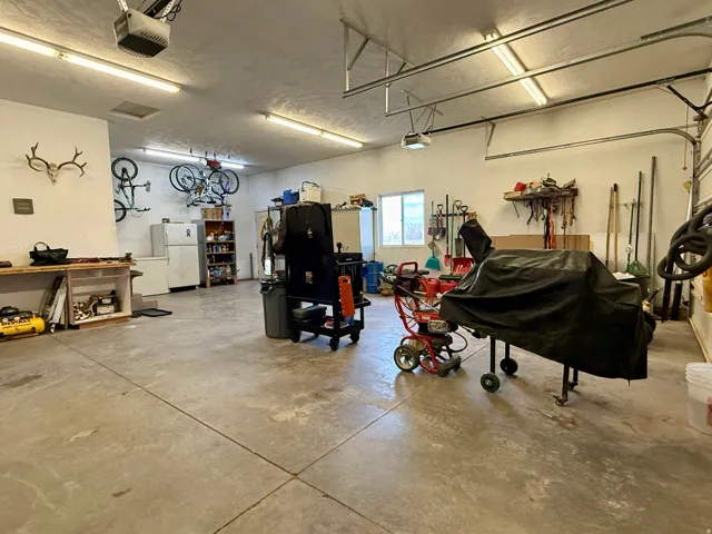 Garage with freestanding refrigerator and a garage door opener