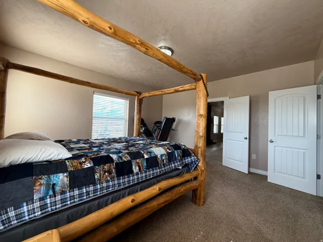 Bedroom featuring dark colored carpet and a textured ceiling