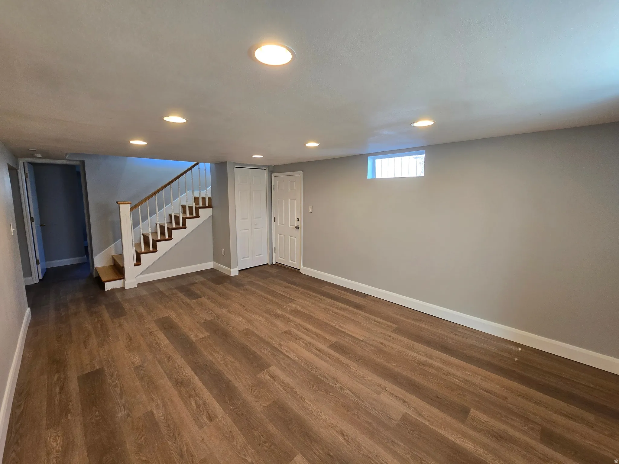 Below grade area with dark wood-type flooring and recessed lighting