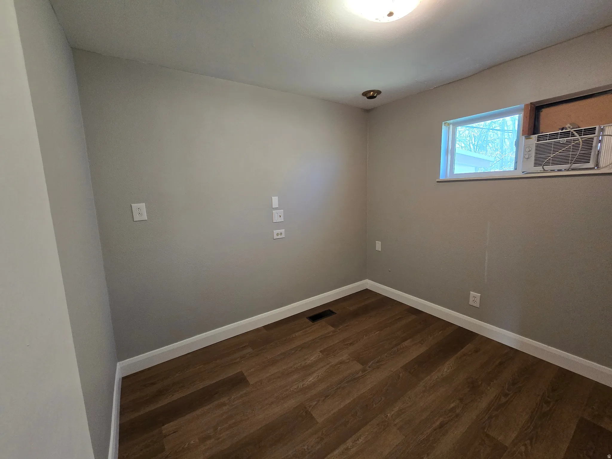 Empty room featuring dark wood finished floors