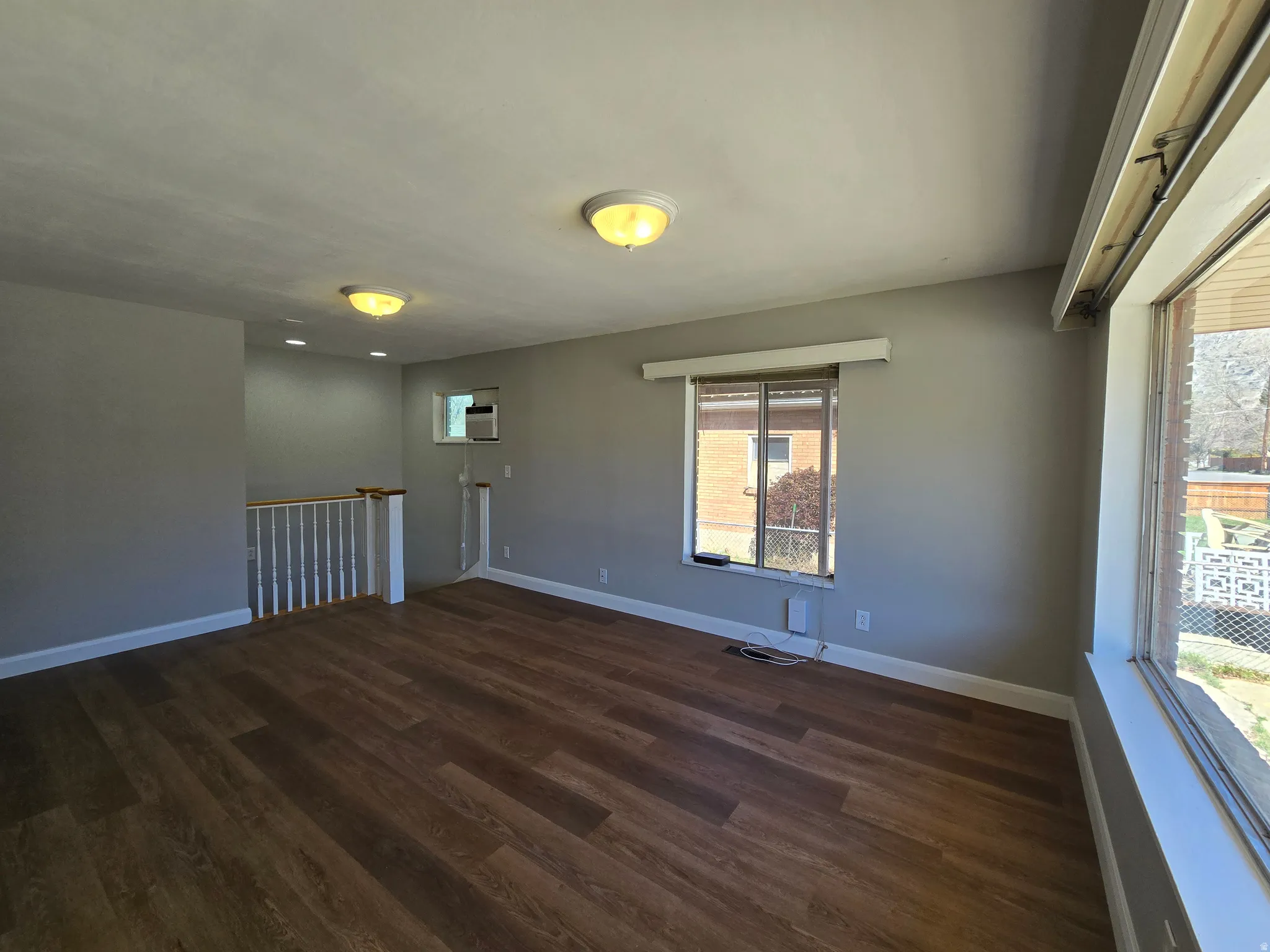 Spare room featuring dark wood-style floors and baseboards