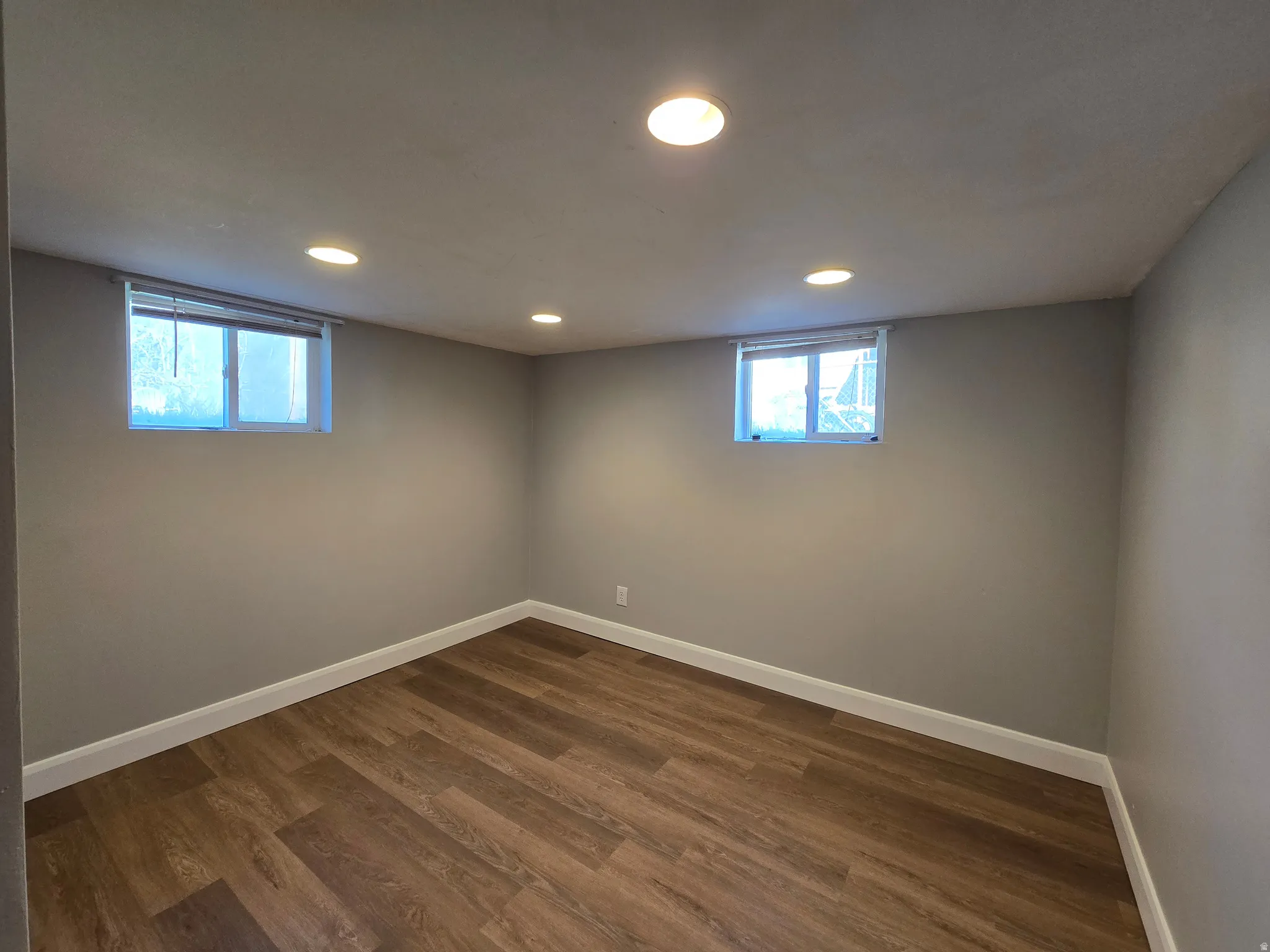 Below grade area featuring recessed lighting, dark wood-type flooring, and plenty of natural light