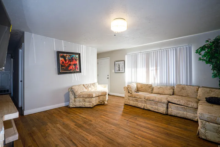 Living room featuring a textured ceiling and dark wood-style floors