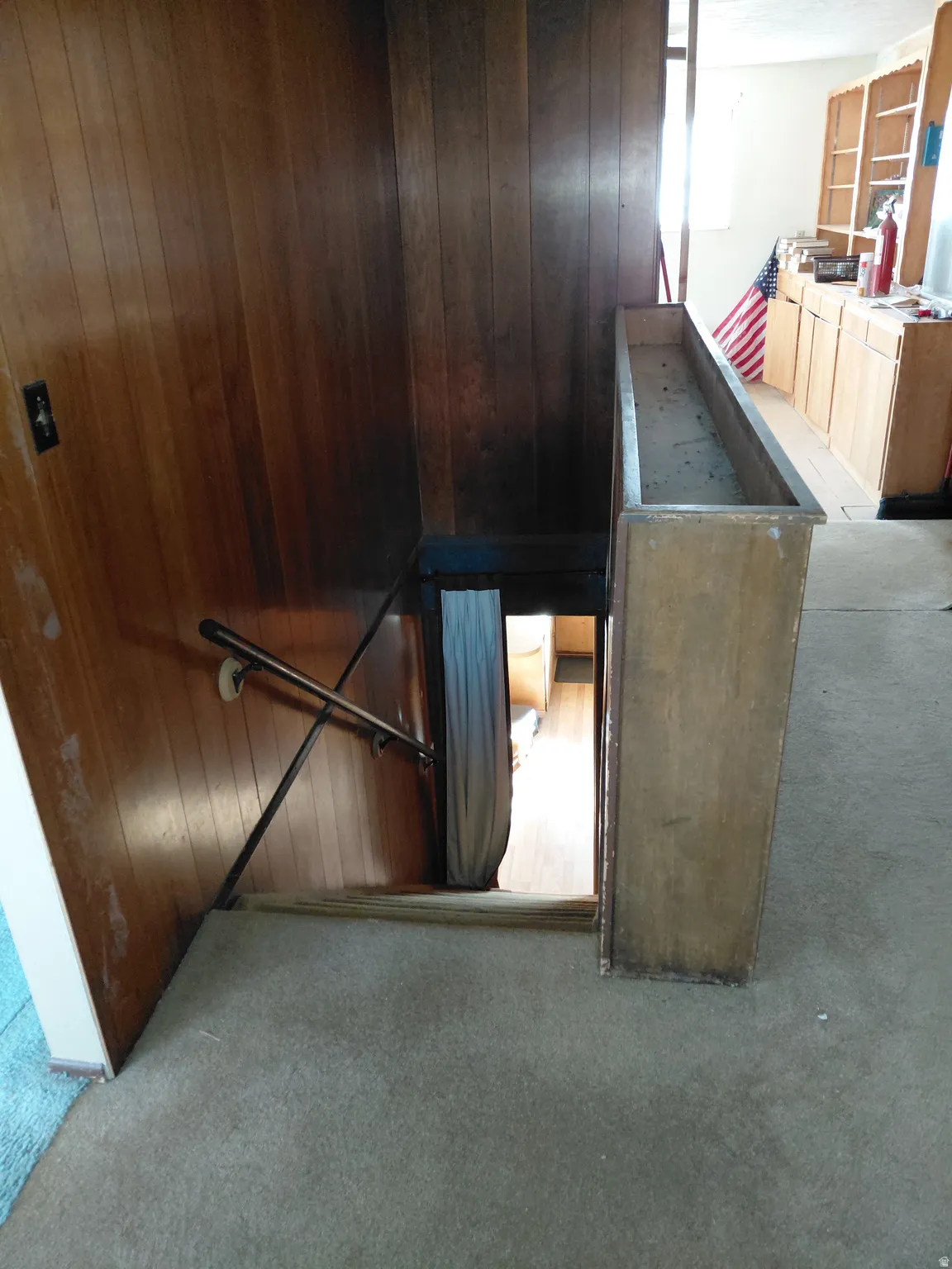 Stairs down to basement with carpet
