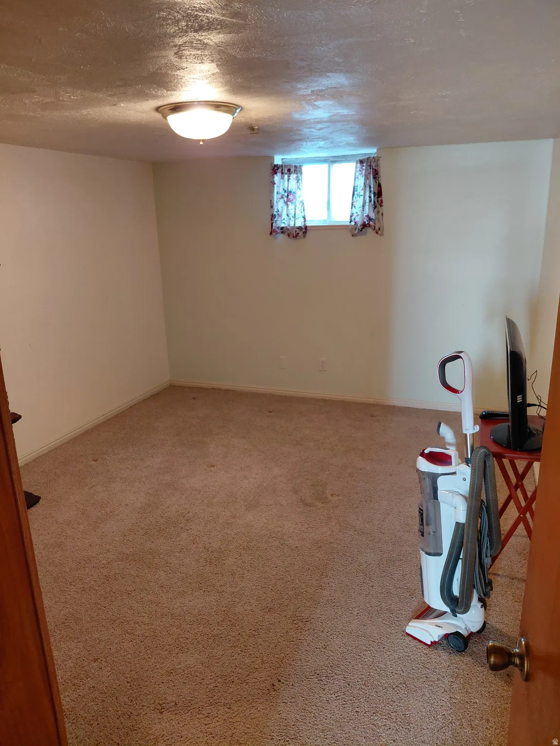 Bedroom featuring a textured ceiling and light carpet