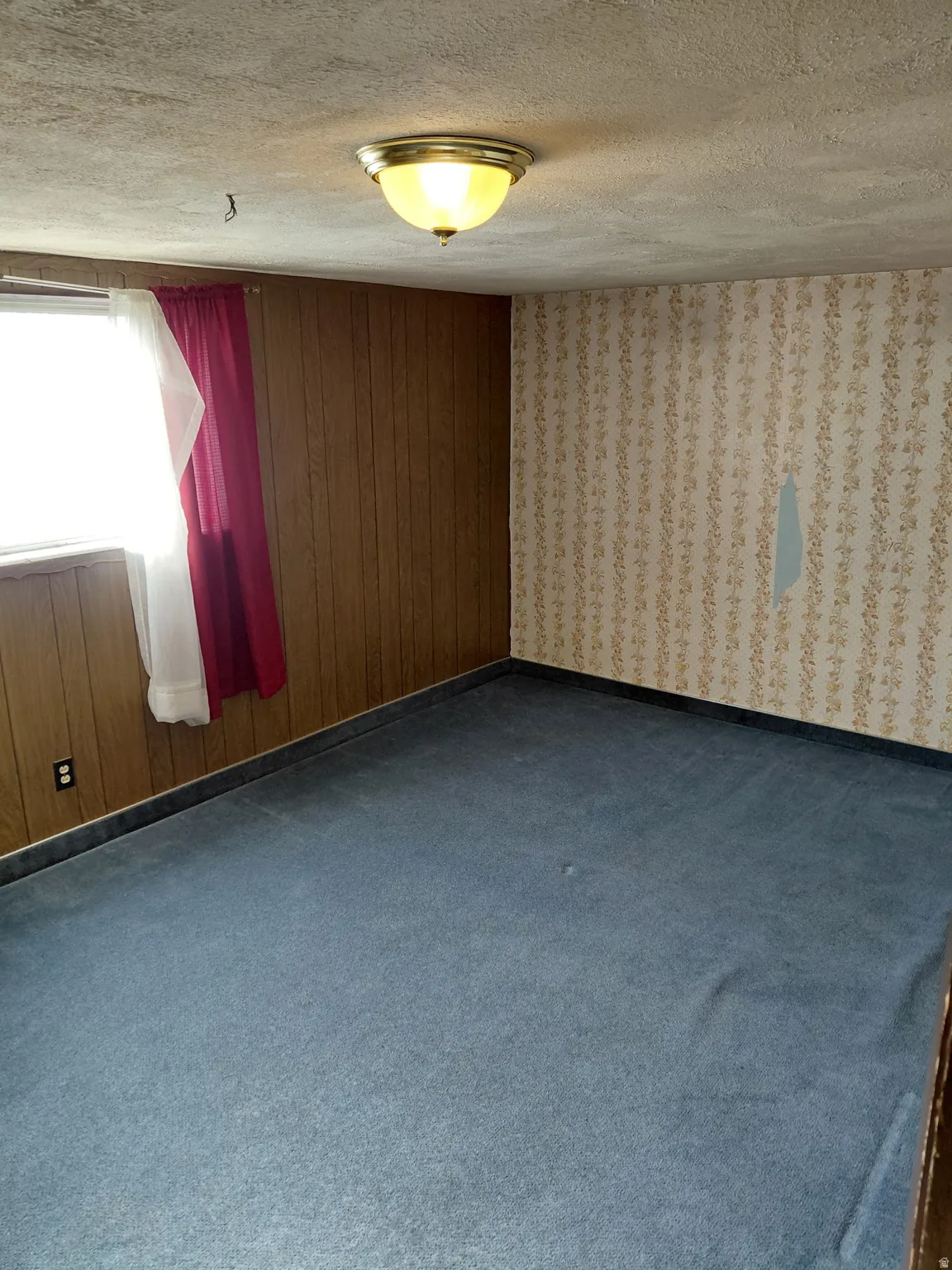 Bedroom with dark carpet and a textured ceiling