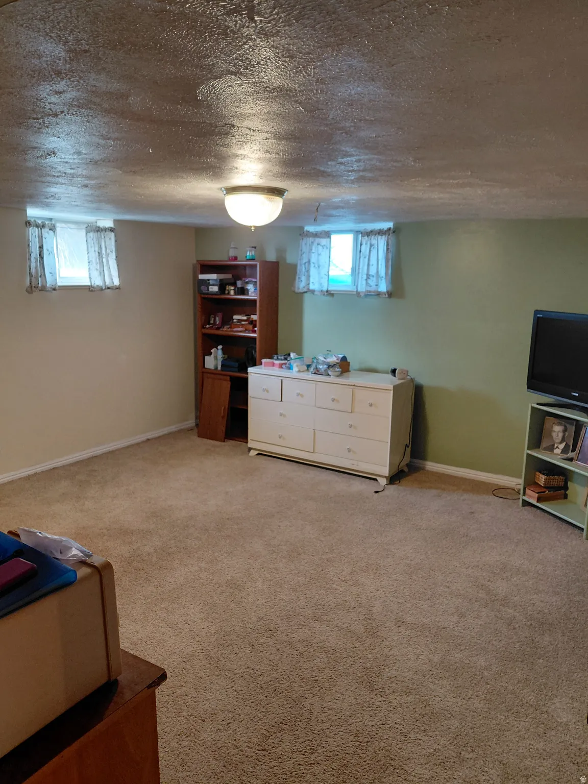 Bedroom with light carpet and a textured ceiling