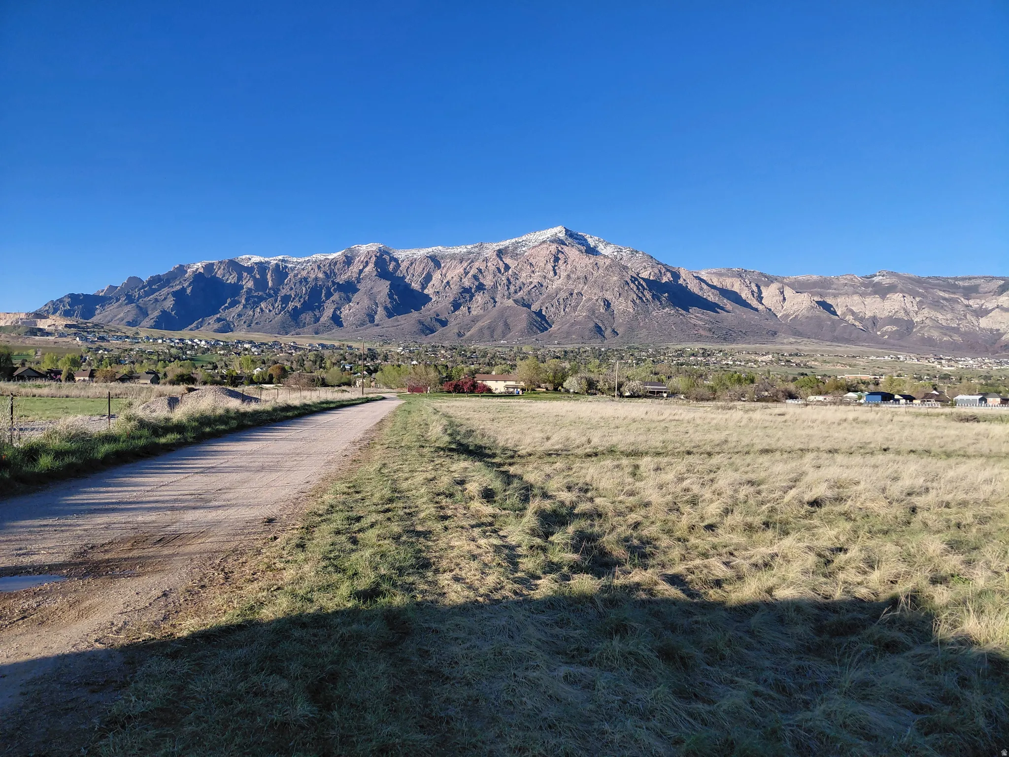 View of home and property looking North down long dirt driveway from Hwy 89