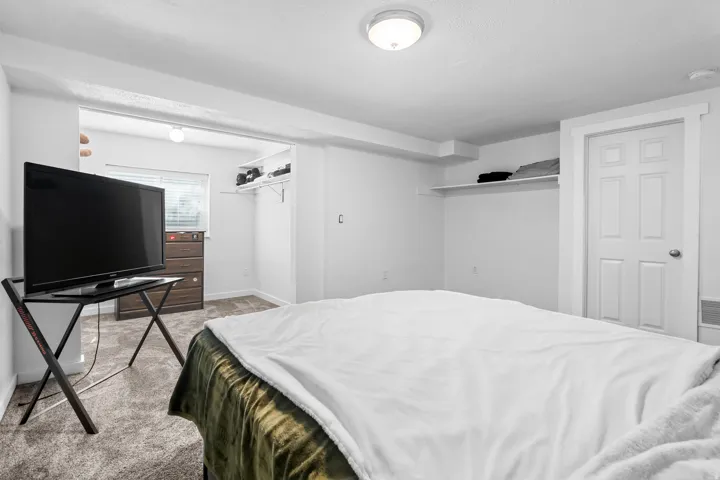 Bedroom featuring light colored carpet and baseboards
